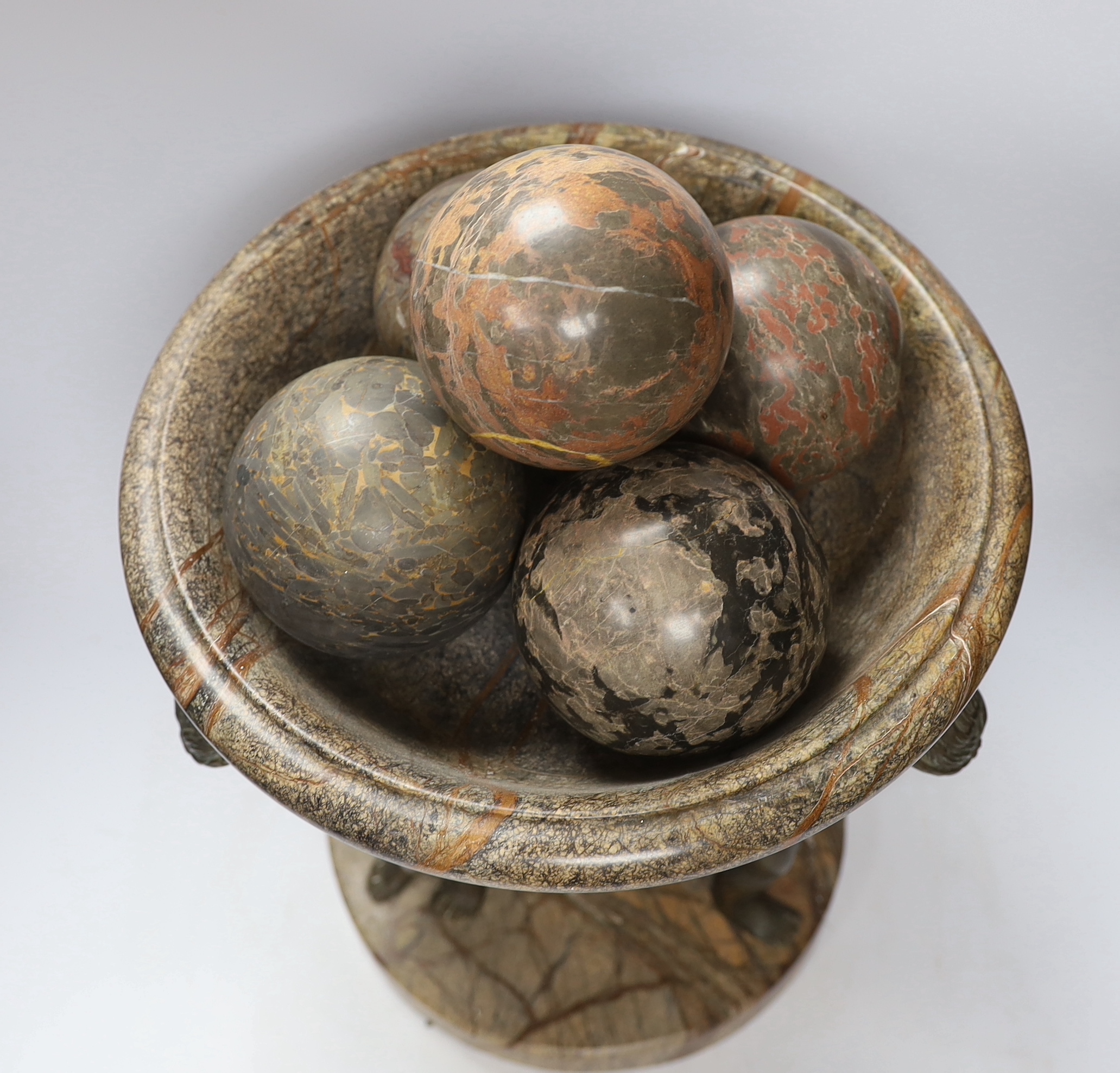 A reconstituted marble and bronzed metal Atlas tazza centrepiece with four stone spheres, 49cm high